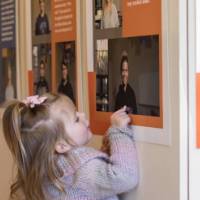 A little girl points to a photo in the exhibit